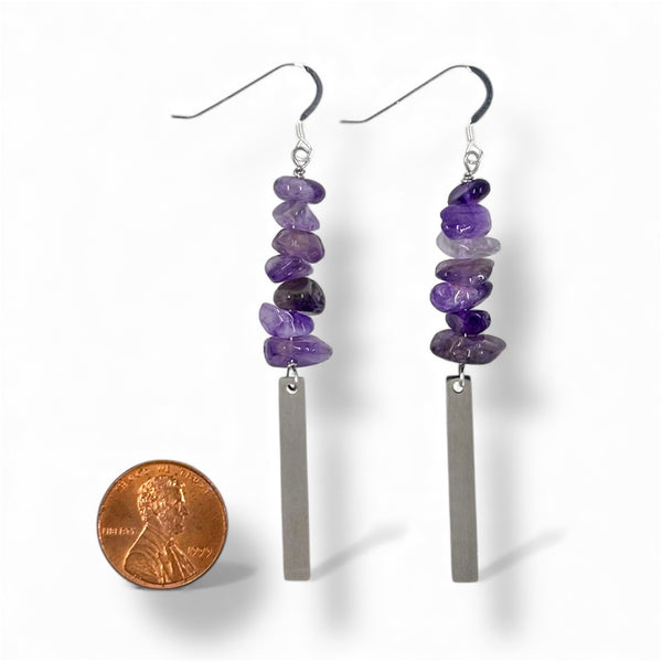 Pair of purple beaded earrings with a silver bar, shown with a penny for scale on a white background.