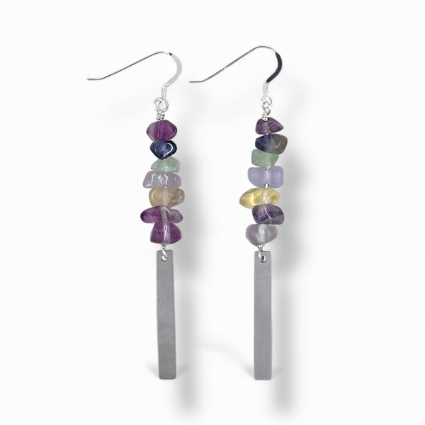 Pair of earrings with colorful Rainbow Fluorite gemstone beads and a stainless steel bar on a white background